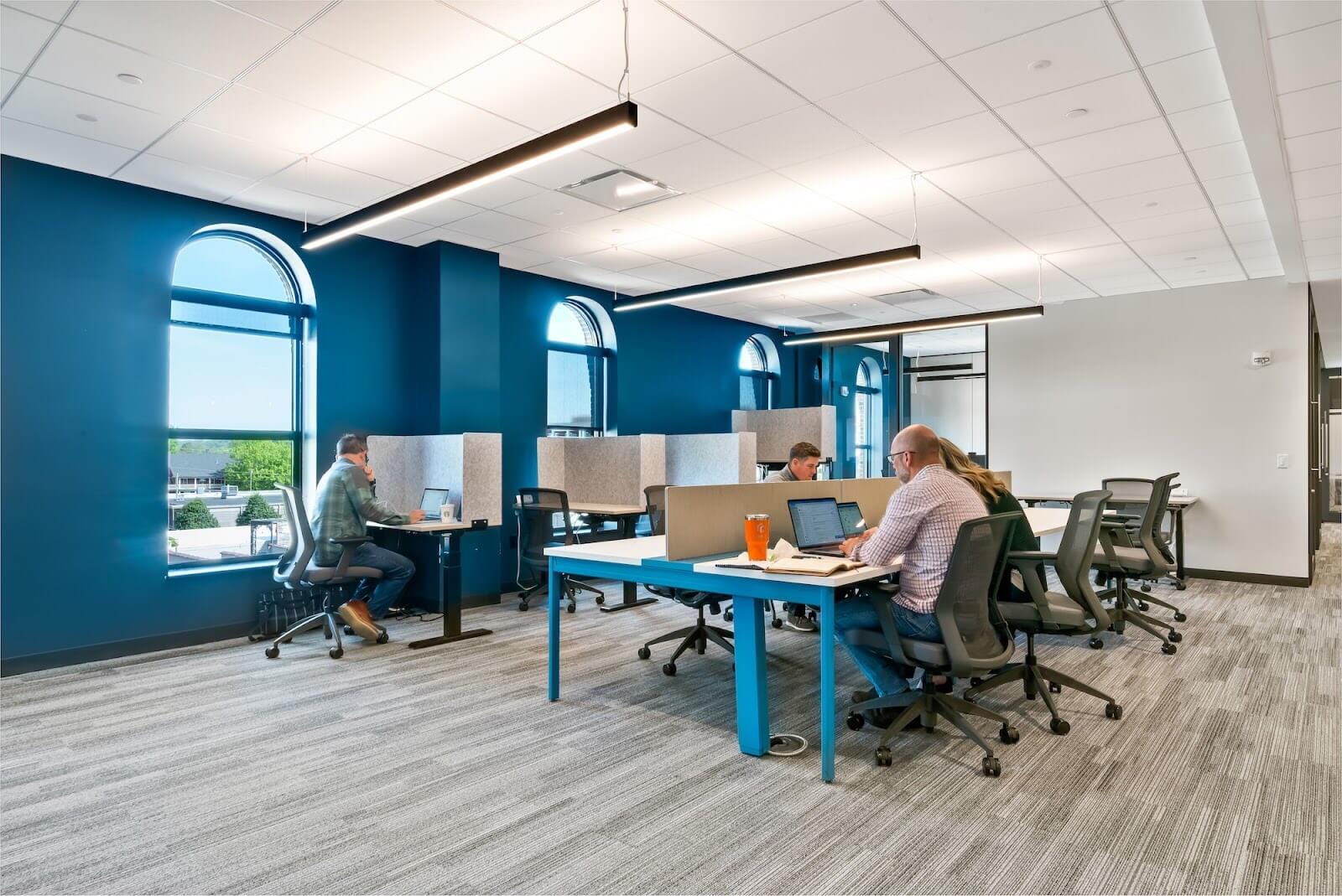 Four people working in a collaborative workspace.