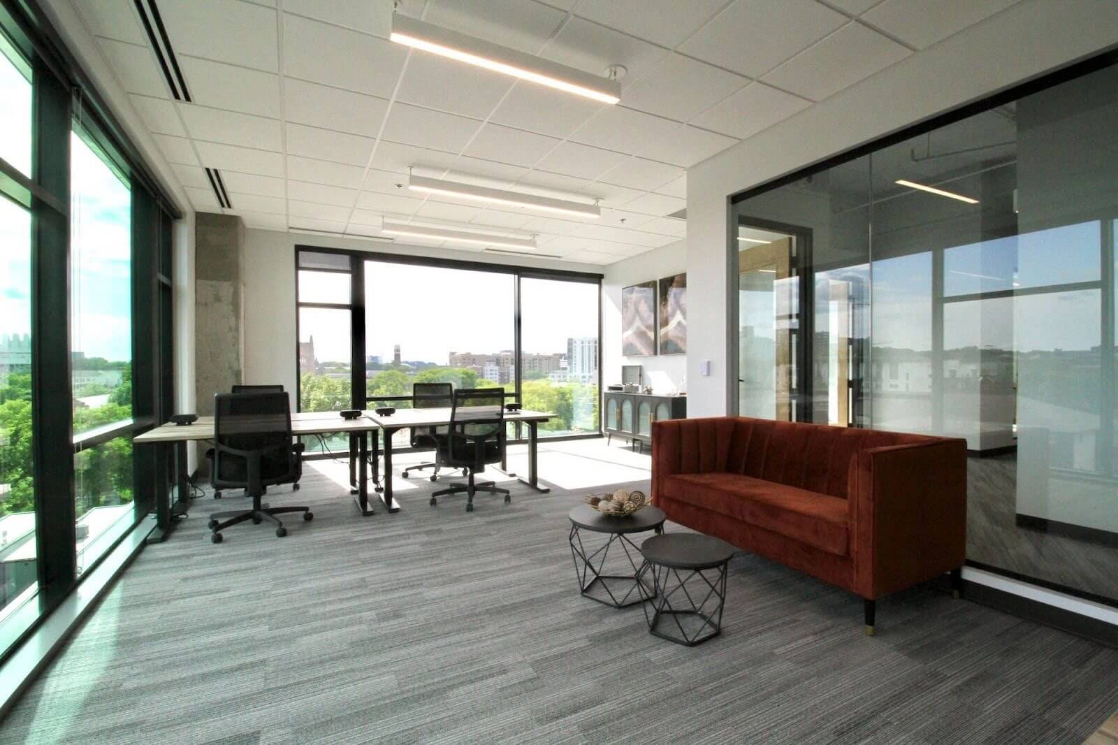 Office with a large table and red couch.